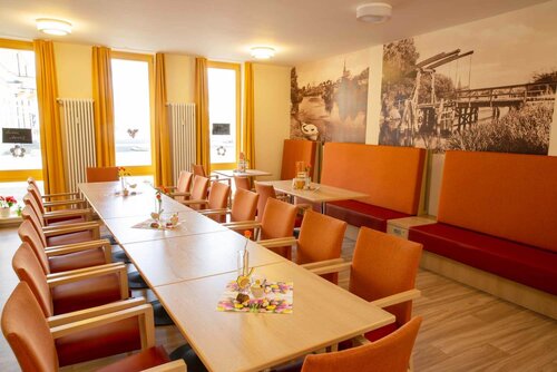 Separater Raum des Bistro Sonnenseite für Feierlichkeiten mit einer langen Tafel und Sitzbänken