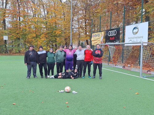 Das Team Garten- und Landschaftsbau steht auf dem Fußballplatz zusammen.