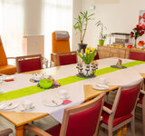 Ein großer gedeckter Tisch mit Stühlen in der Tagespflege Demmin